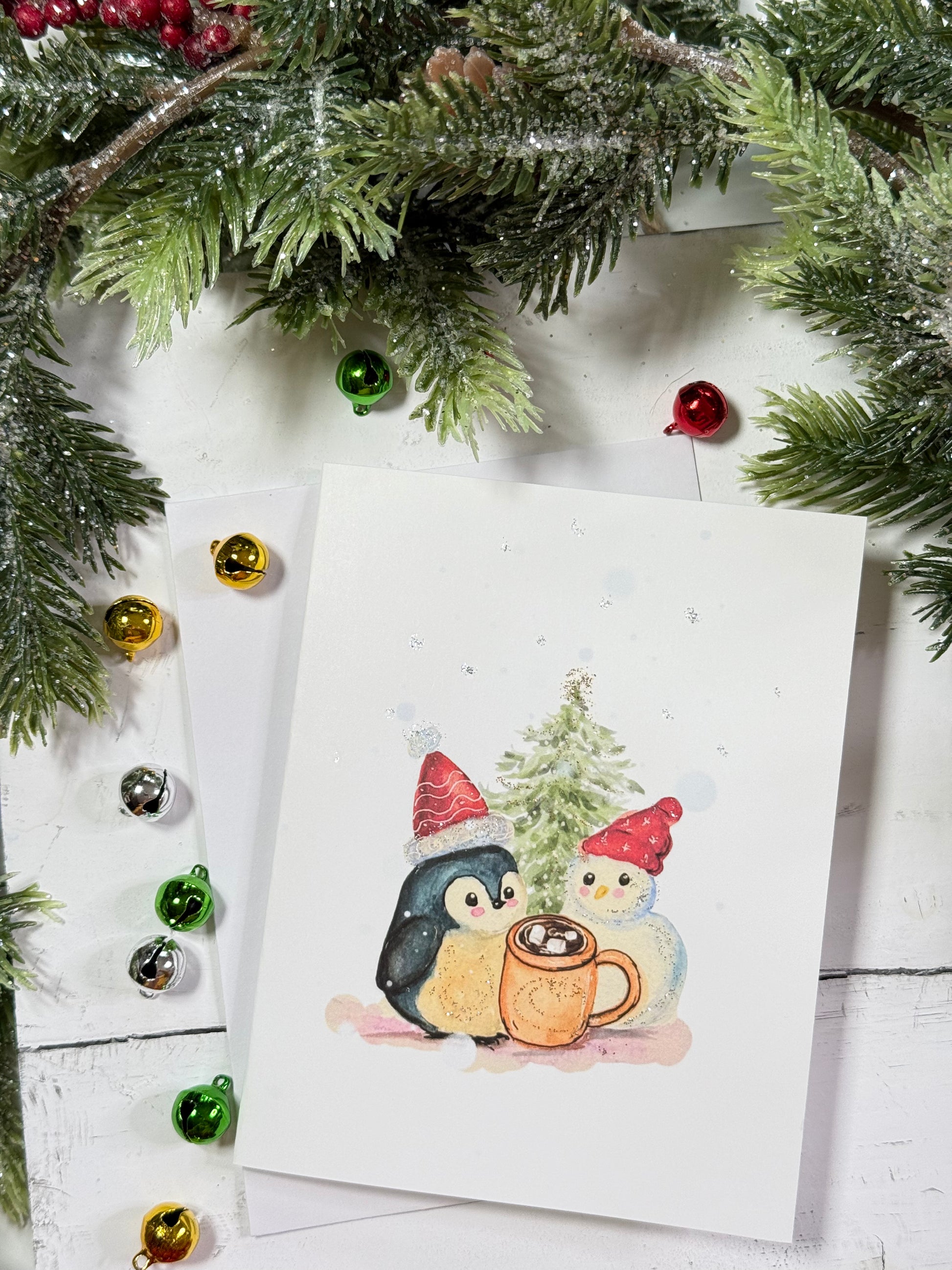 Christmas-themed card with penguins and a snowman under festive decorations.