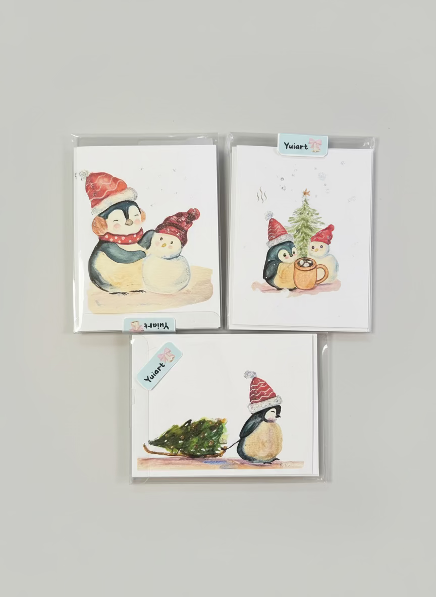 Set of Christmas-themed cards with penguins and snowmen, surrounded by greenery and berries.